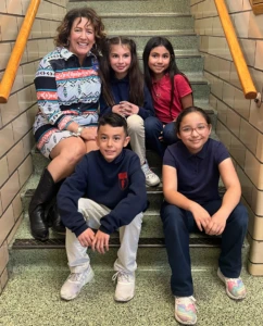 teacher sitting on stairs with students